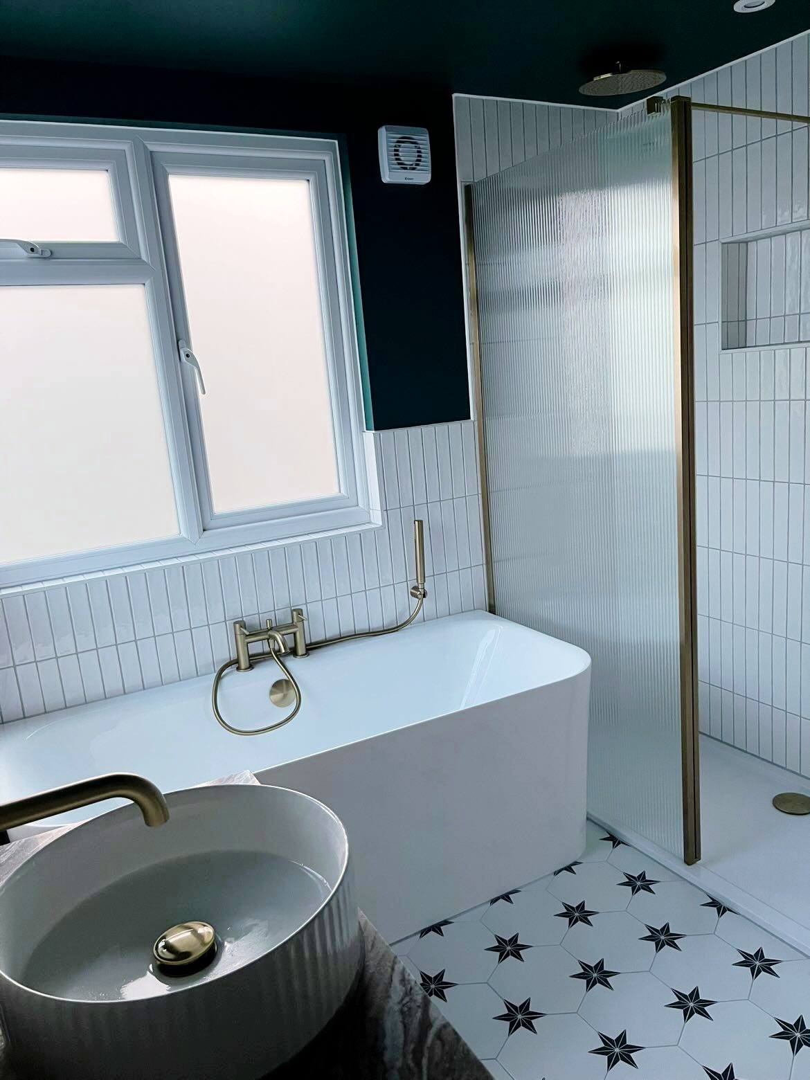 Teal bathroom with gold bath taps and walk-in shower