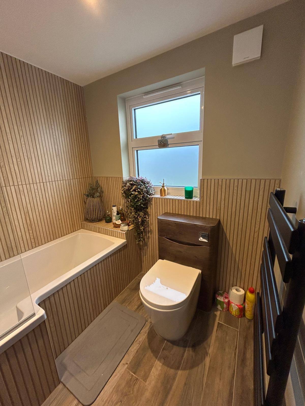 Wood slat bathroom with bath and window light