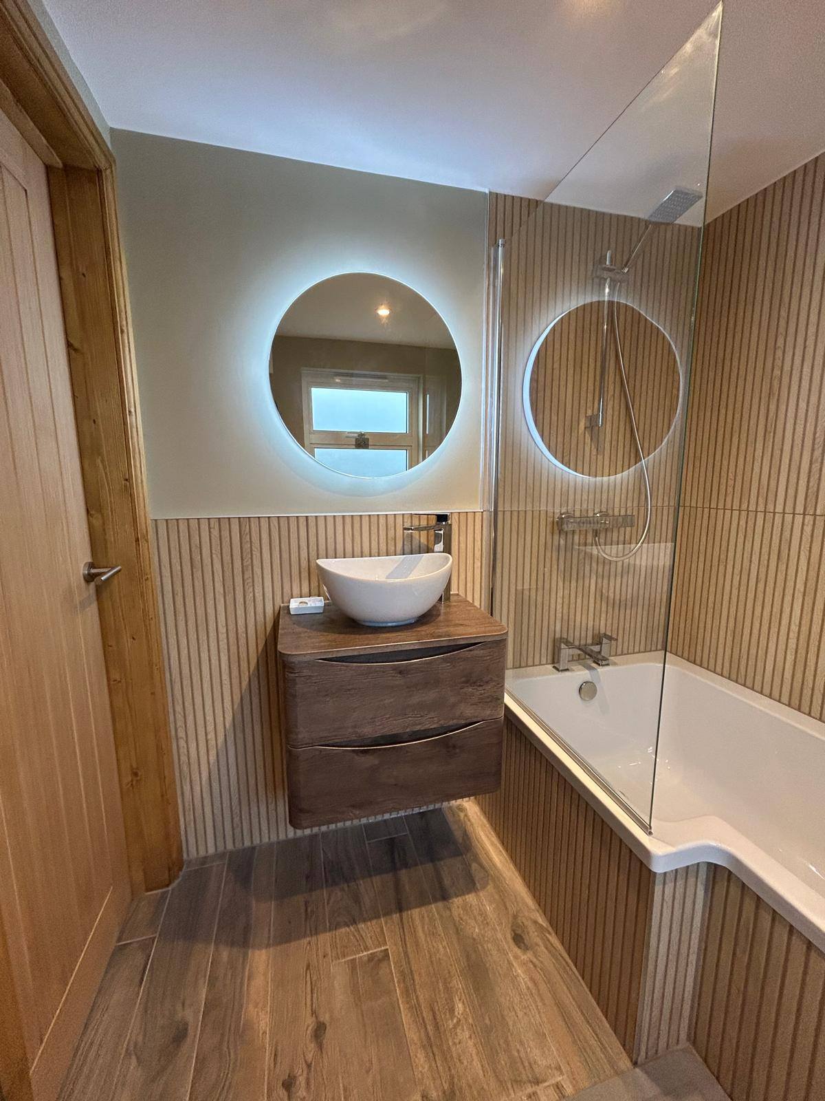 Wood slat bathroom with round LED mirror