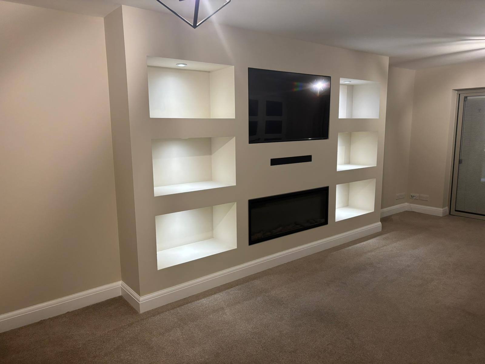 Completed media wall with lit alcoves TV and bio fire