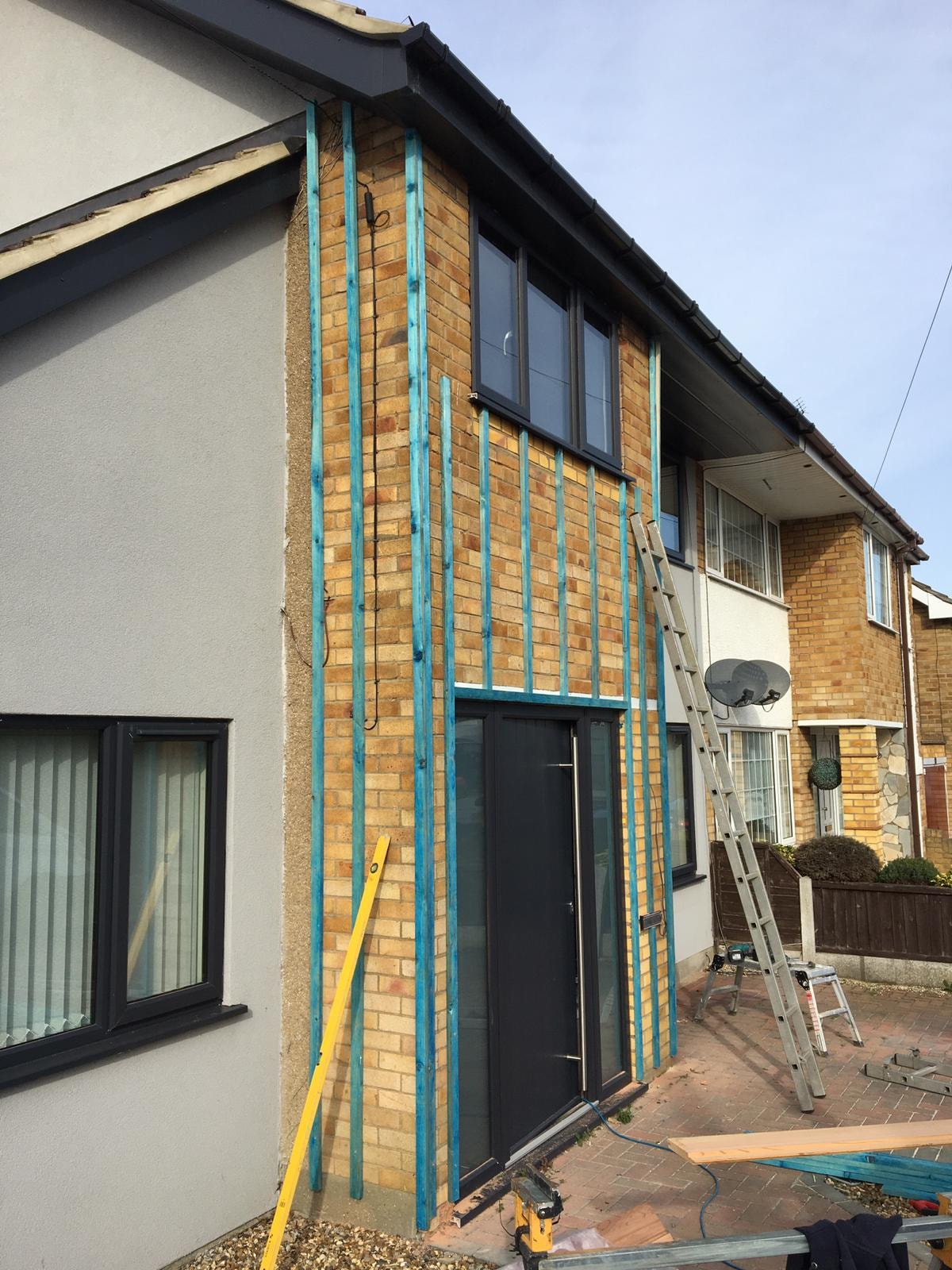Cedar cladding installation in progress with batten framework