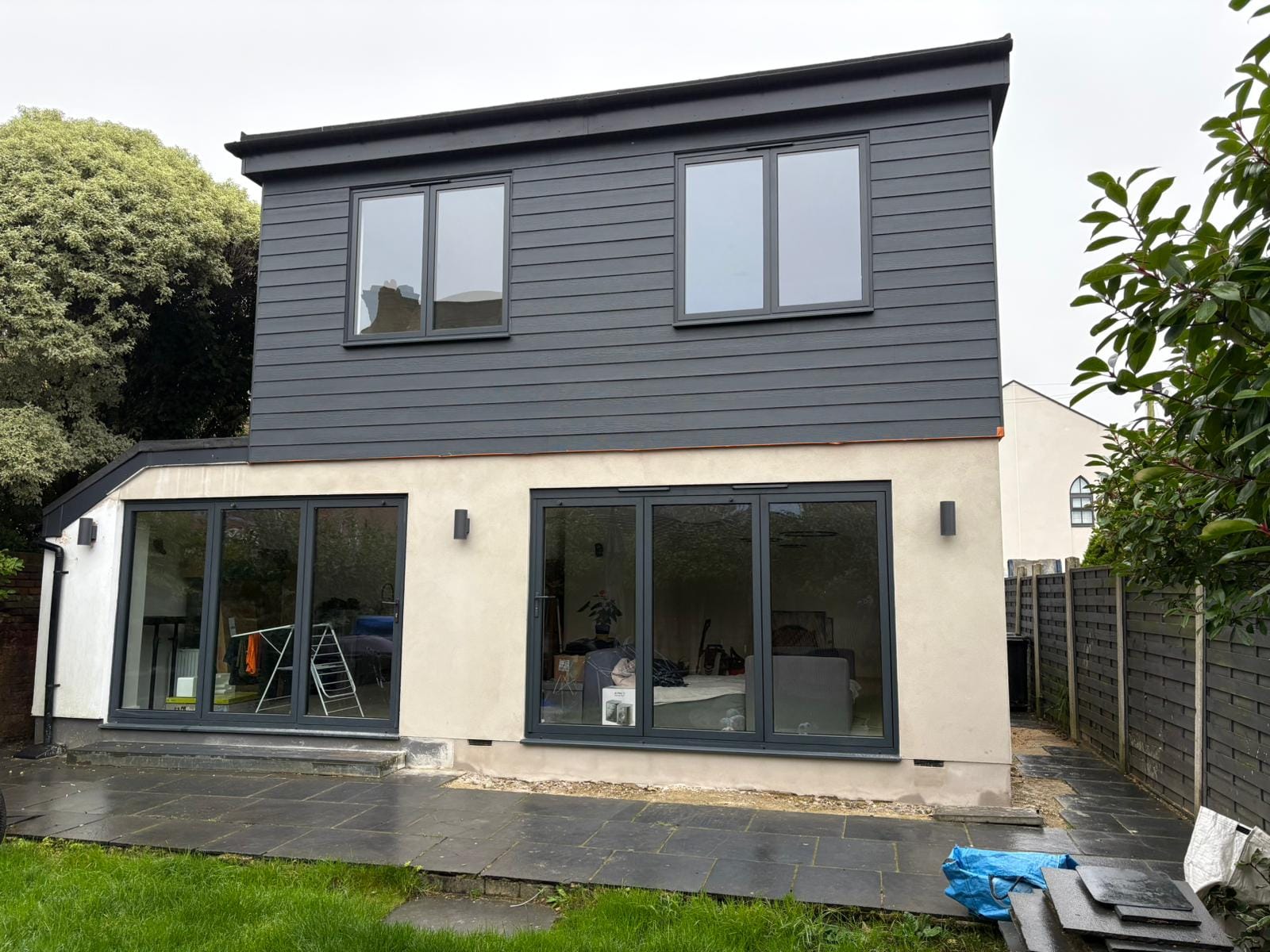 Two-storey extension with dark cladding and bifolds