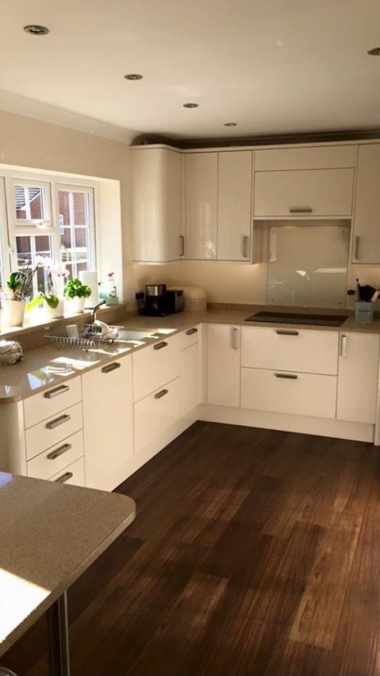 White gloss kitchen with warm hardwood flooring